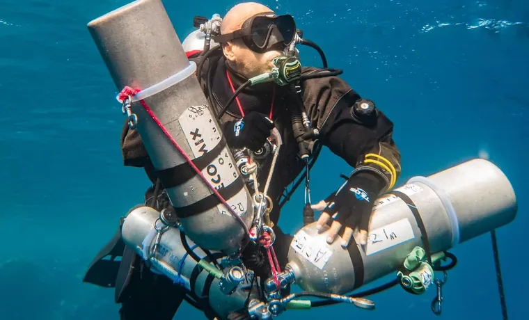 Technical diver managing trimix stage cylinders during decompression