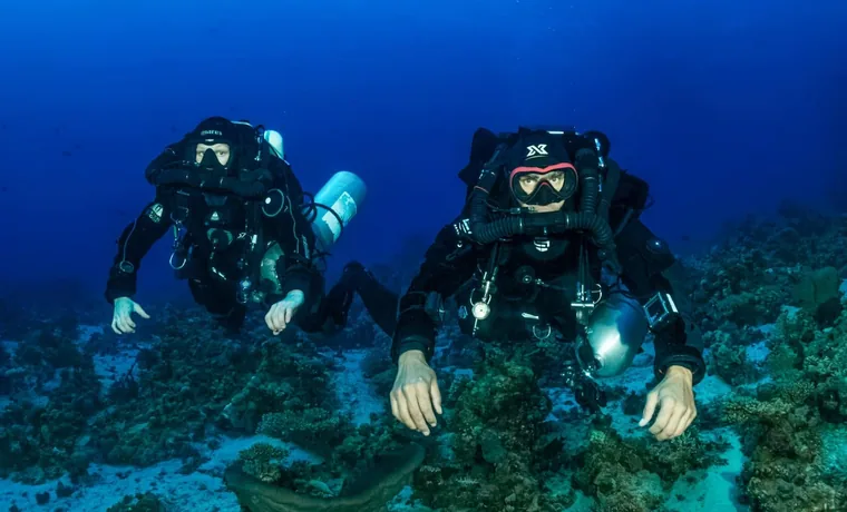 Technical divers in twinset configuration over a Red Sea reef