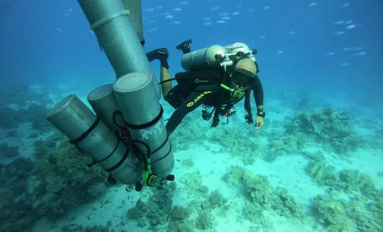 Technical diver carrying a stage cylinder, Red Sea