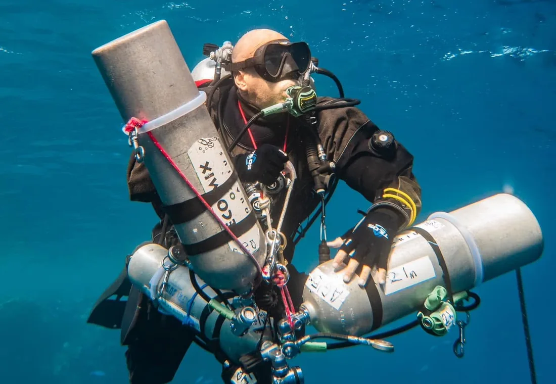 Technical diver managing trimix stage cylinders in the Red Sea